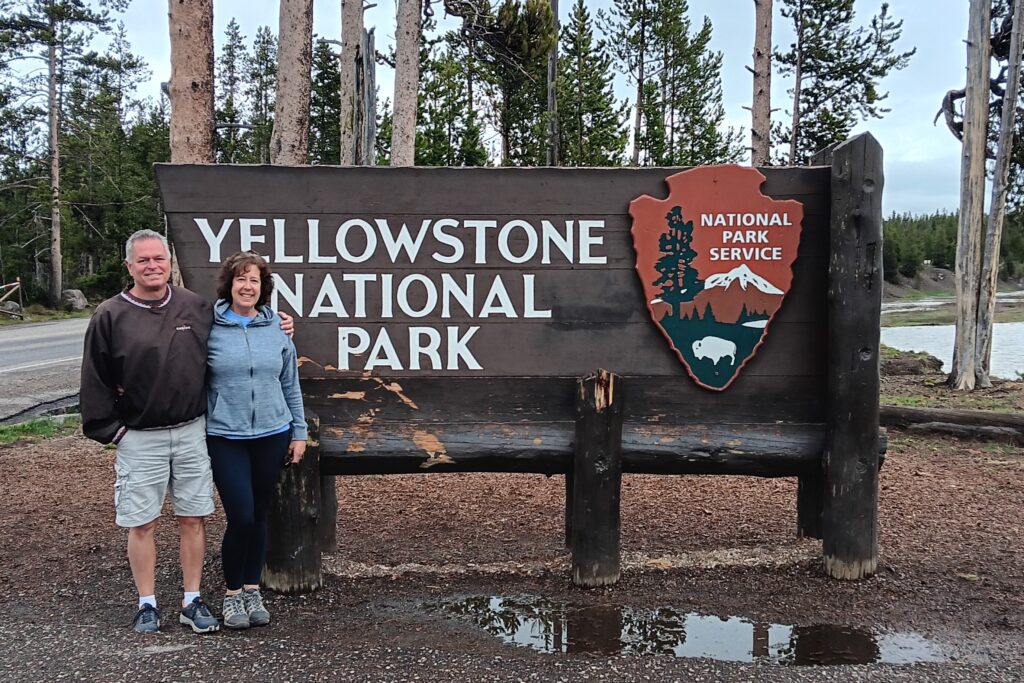 Karen and Steve at entrance sign for Yellowstone National Park
